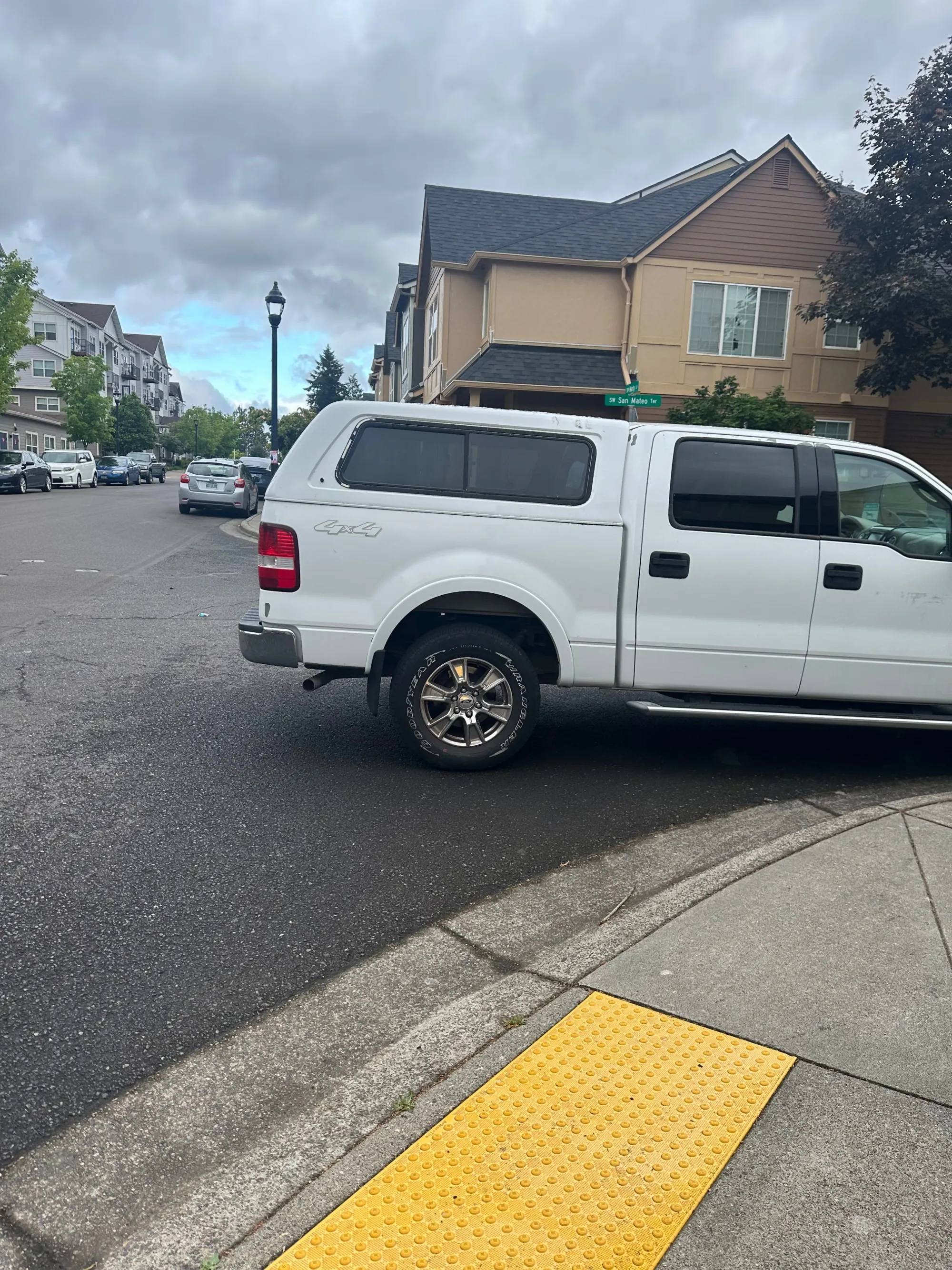 white Ford truck with topper blocking a crosswalk. 